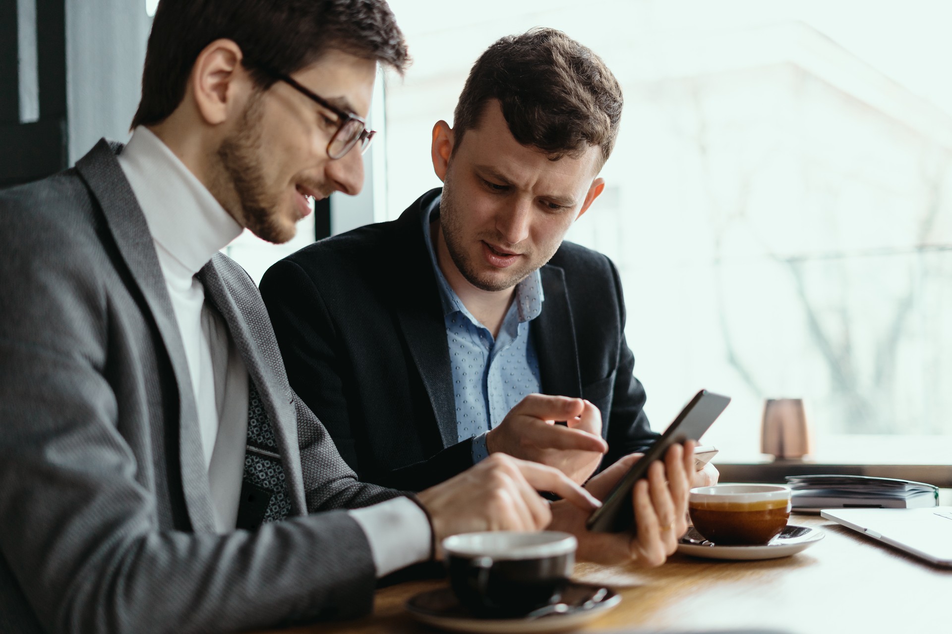 Two businessmen having a conversation using a smartphone